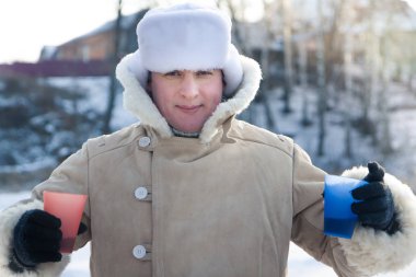 Soğuk güneşli kış günü açık havada şarap ile kış tatilleri sırasında neşeli genç adam alkış