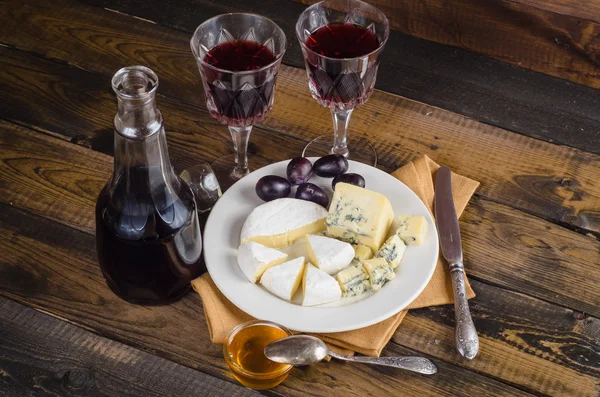 Cheese plate with grape and wine on wood — Stock Photo, Image