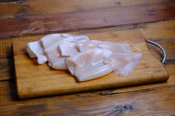 Ahşap arkaplanda ham mürekkep balığı bileşimi