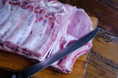 Tahta arka planda pirzola ve taze çiğ domuz filetosu.