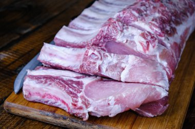 Tahta arka planda pirzola ve taze çiğ domuz filetosu.