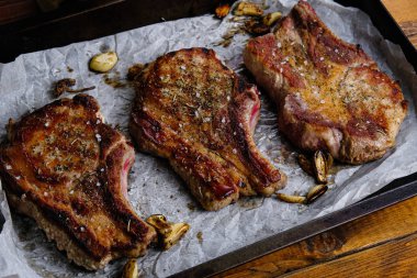 Ahşap arka planda pirzola ve kızarmış domuz filetosu.