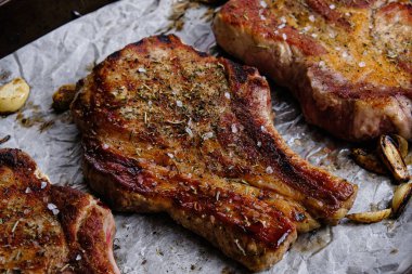 Ahşap arka planda pirzola ve kızarmış domuz filetosu.