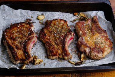 Ahşap arka planda pirzola ve kızarmış domuz filetosu.