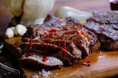 Ahşap arka planda pirzola ve kızarmış domuz filetosu.