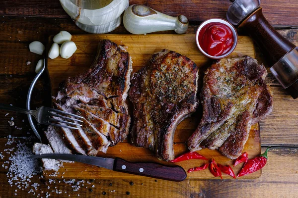 Ahşap arka planda pirzola ve kızarmış domuz filetosu.