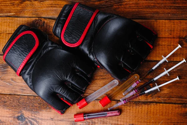 Mma Handschuhe und Steroid Medikamentenzusammensetzung auf einem hölzernen Hintergrund — Stockfoto