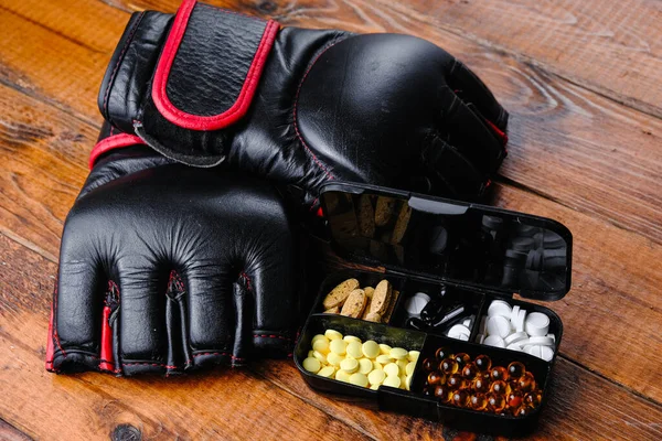 Mma Handschuhe und Steroidmedikamente mit Sporternährungszusammensetzung auf Holzgrund — Stockfoto