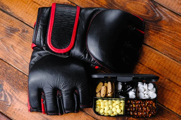 Mma Handschuhe und Steroidmedikamente mit Sporternährungszusammensetzung auf Holzgrund — Stockfoto