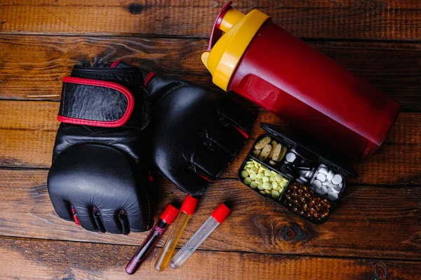 Mma Handschuhe und Steroidmedikamente mit Sporternährungszusammensetzung auf Holzgrund — Stockfoto