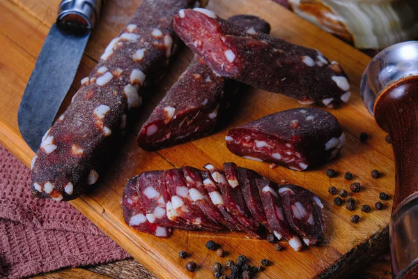 Dried pork sausages composition on a wooden background — Stock Photo, Image