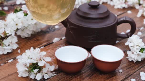 Composición de la ceremonia del té chino sobre fondo de madera con hojas de cereza — Vídeo de stock