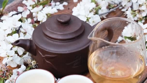 Composición de la ceremonia del té chino sobre fondo de madera con hojas de cereza — Vídeos de Stock