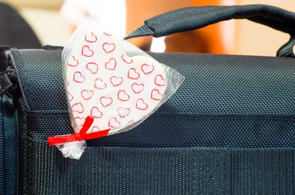 Heart shaped lollipop inserted in bag\'s belt