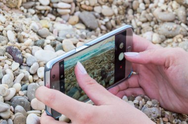 Deniz kıyısı bir smartphone kullanarak resim çekme