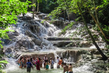Ocho Rios, Jamaica - November 15, 2016: The Dunn's River Falls are waterfalls in Ocho Rios in Jamaica, which can be climbed by tourists. clipart