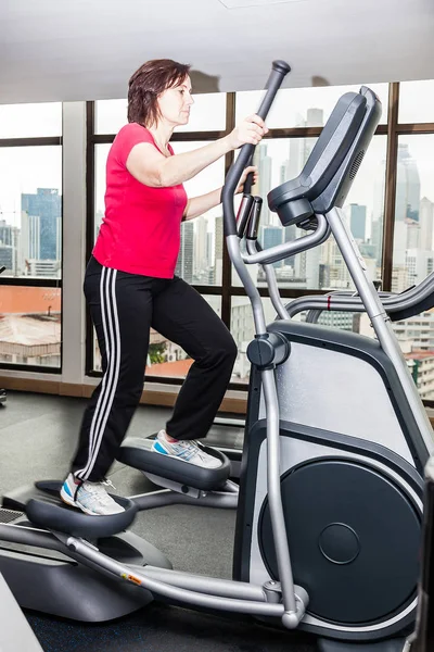 Woman is training on a crosstrainer — Stock Photo, Image