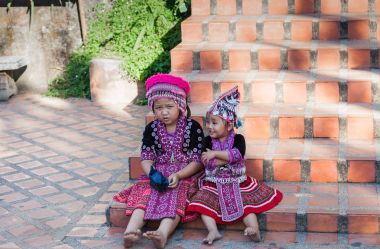 Chiang Mai, Tayland - 06 Kasım 2015: Tay çocuklar Chiang Mai altın tapınak merdivenlerde geleneksel giysiler içinde.