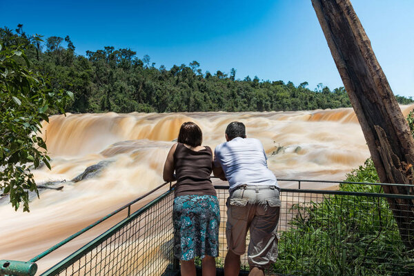 Man and woman on the Saltos del Monday a waterfall near the city Ciudad del Este in Paraguay