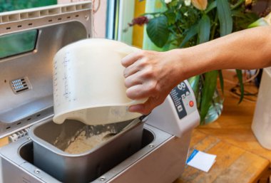 Bir kadının eli ekmek makinesinde çalışıyor..