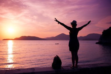 Gün batımında sahilde kadın siluet