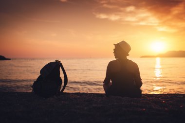 Gün batımında sahilde kadın siluet