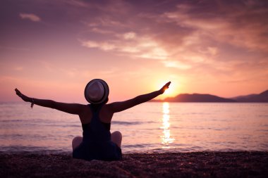 Gün batımında sahilde kadın siluet