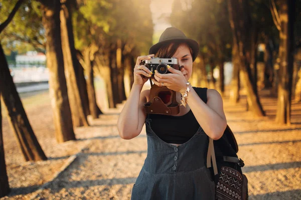 Mulher com câmera vintage no beco do parque ao pôr do sol — Fotografia de Stock