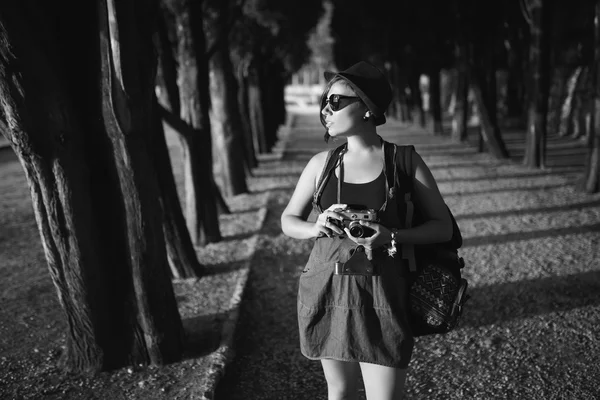 Γυναίκα με vintage φωτογραφική μηχανή στο πάρκο σοκάκι στο ηλιοβασίλεμα — Φωτογραφία Αρχείου