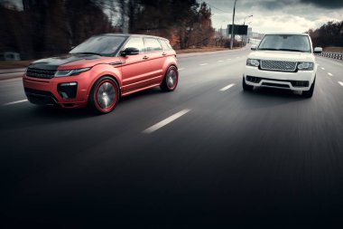 Arabalar Land Rover Range Rover sürücü sonbahar güneşli gündüz, asfalt şehir yolda