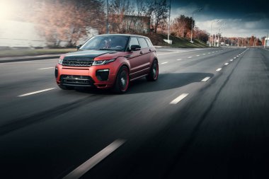 Arabalar Land Rover Range Rover sürücü sonbahar güneşli gündüz, asfalt şehir yolda