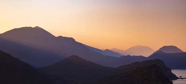 Силуэты слоистых гор на закате, природный ландшафт — стоковое фото