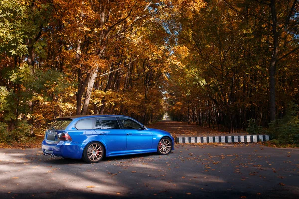 蓝色的车宝马 3 系列 E91 站在秋天的公园树林附近 — 图库照片