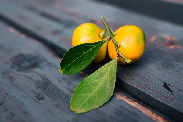 Ahşap masa, yaprakları ile portakal mandalina — Stok fotoğraf