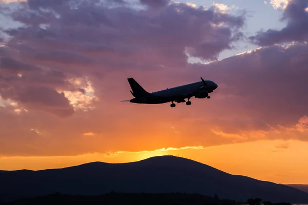 夕日で空を飛んでいる旅客機 — ストック写真