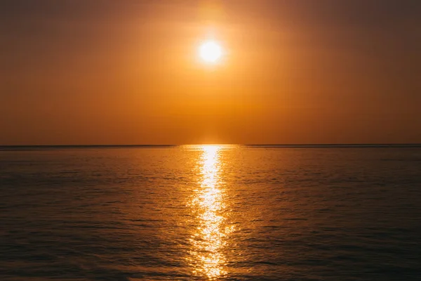 Puesta de sol en vista al mar, sol reflejado en el agua — Foto de Stock
