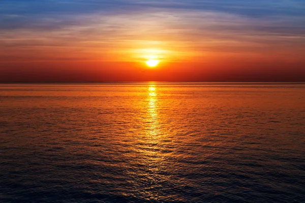 Pôr do sol na vista do mar, o sol refletido na água — Fotografia de Stock