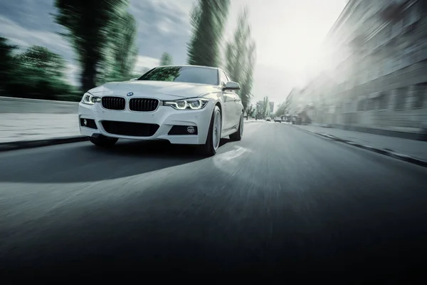 Blanco BMW Serie 3 F30 coche está conduciendo en carretera de asfalto en verano durante el día —  Fotos de Stock