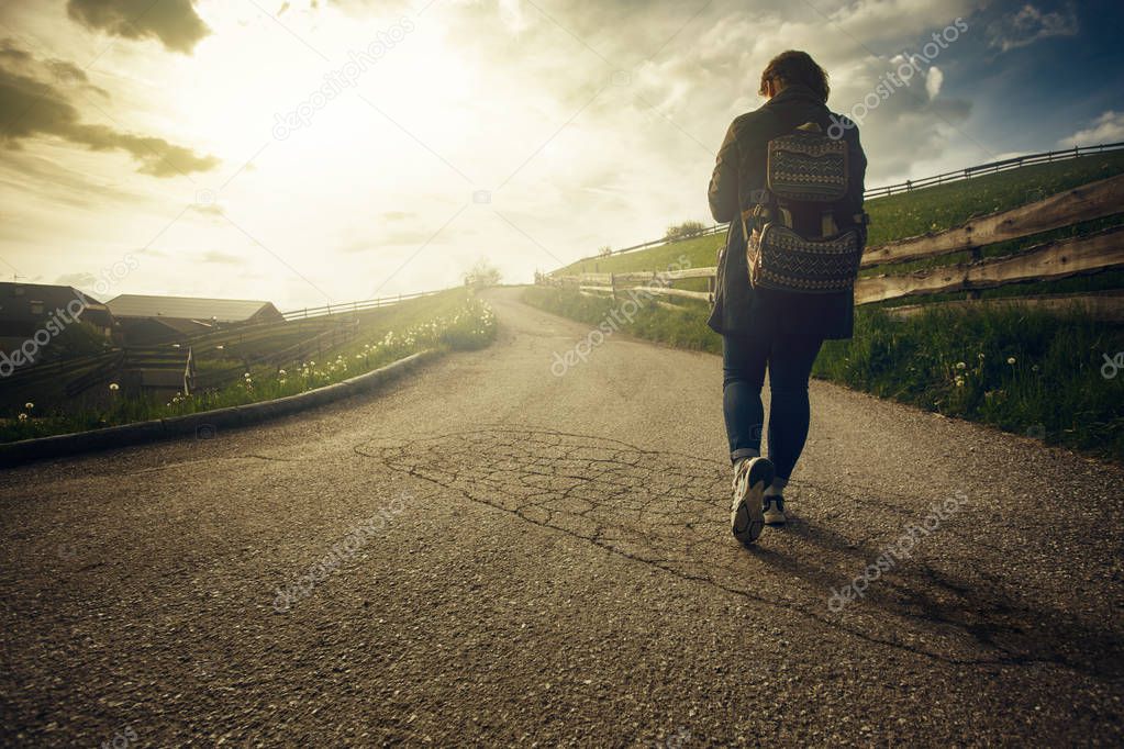 Woman is walking on the road 