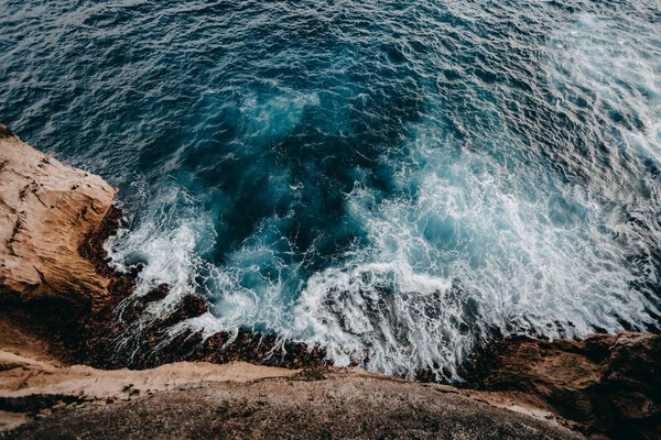 Aerial view to ocean waves and rock coast