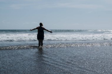 Eller yukarı deniz kumsalda bir kadındır. Uzanmış silah kaldırdı.