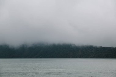Alçak bulutlar dağ yakın göl üzerinde. Sakin sahne manzara