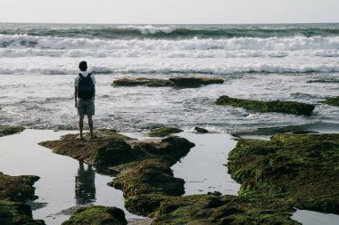 Adam sahilde duran ve denize mesafe içine arıyorum