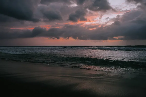 Драматические золотые облака заката отражаются в водном море . — стоковое фото