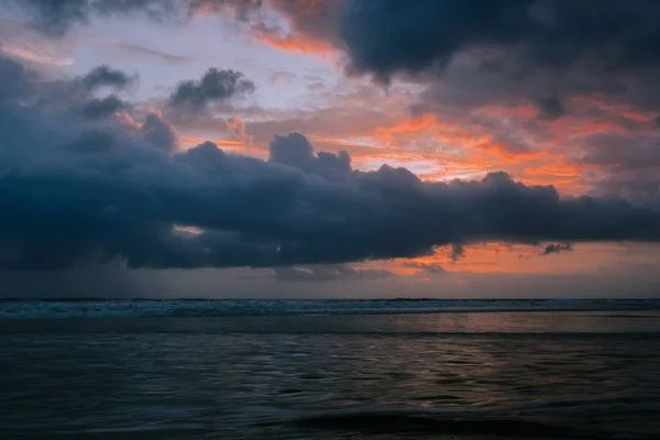 Драматические золотые облака заката отражаются в водном море . — стоковое фото