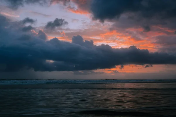 Dramáticas nubes doradas al atardecer reflejadas en el mar de agua . — Foto de Stock