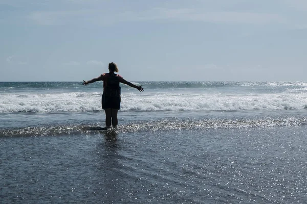 Eller yukarı deniz kumsalda bir kadındır. Uzanmış silah kaldırdı.