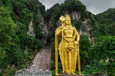 Big golden Lord Murugan statue (Vratvijaya) near entrance to Batu Caves in Kuala Lumpur, Malaysia clipart