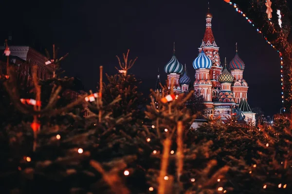 Moskova, Rusya gece St Basil Katedrali. Ön plan üzerinde Noel ağaçları — Stok fotoğraf