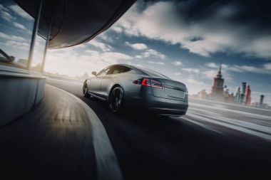 Elektrikli otomobil Tesla Model S P85 hızlı hızlı sürücü batımında yolda. Arkadan Görünüm